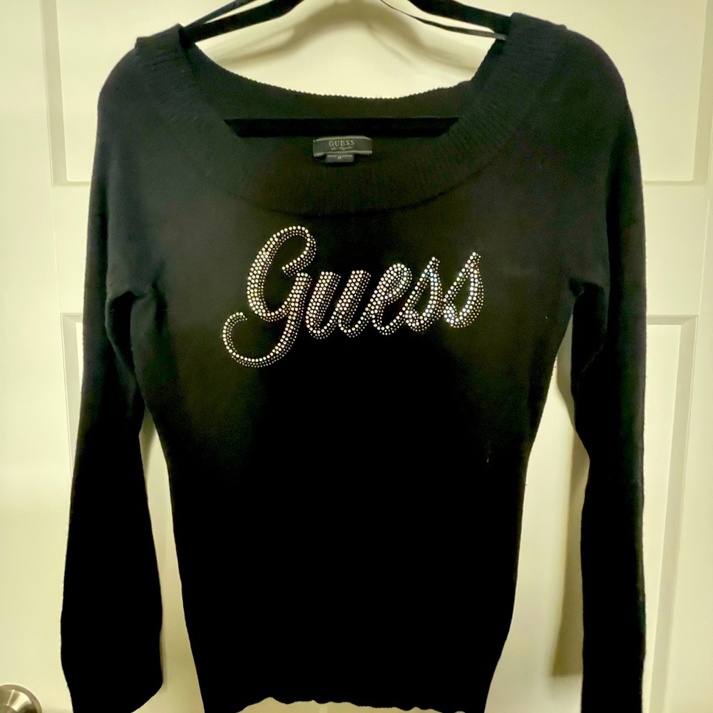 Black Guess off the shoulder sweater with rhinestone accents reading Guess